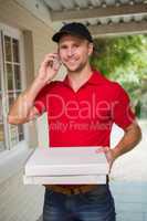 Happy pizza delivery man on the phone