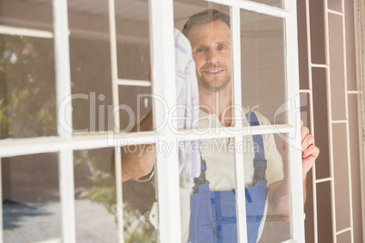Handyman cleaning the window and smiling
