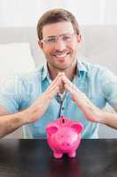 Smiling man with piggy bank