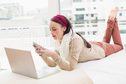 Pretty brunette using laptop on bed Pretty brunette using laptop on bed
