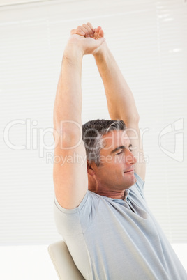 Peaceful man with eyes closed stretching