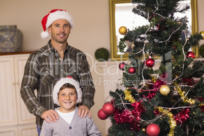 Dad and son posing near the christmas tree