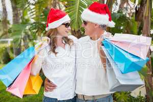 Festive couple holding shopping bags