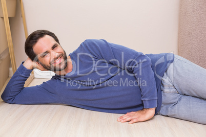 Happy man lying on floor with moving boxes