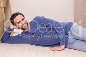 Happy man lying on floor with moving boxes