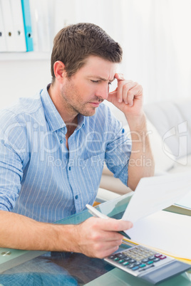 Businessman reading document at his desk in his office