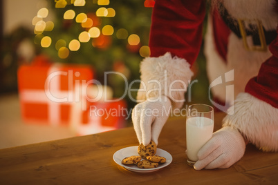 Santa picking cookie and glass of milk