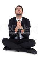 Businessman sitting praying and looking up