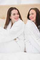 Pretty friends wearing white bathrobes