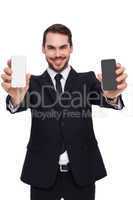 Smiling businessman showing mobile in each hand