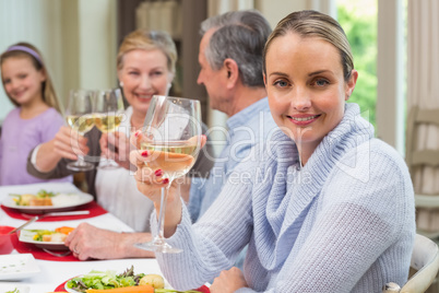 Woman smiling at camera while holding a glass of wine