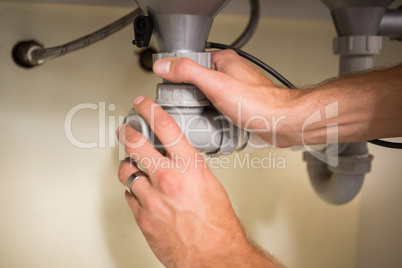 Plumber fixing under the sink