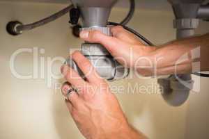 Plumber fixing under the sink