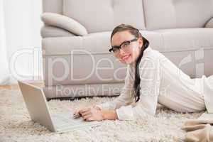 Pretty brunette using laptop on the floor
