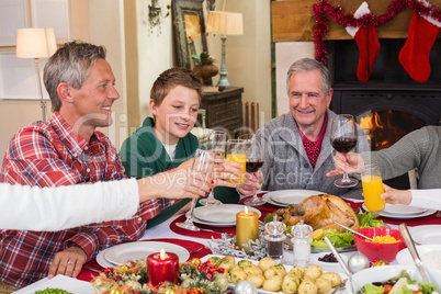 Multi generation family toasting each other at dinner