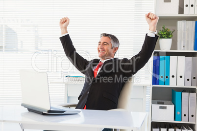 Cheering businessman at his desk