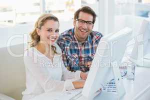 Team going over photo contact sheet smiling at camera