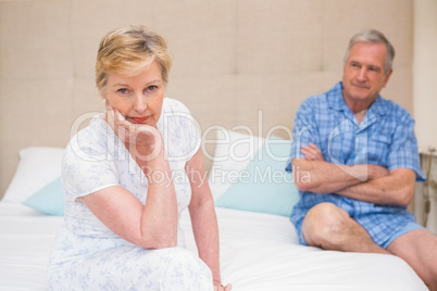Senior couple not speaking after an argument on bed