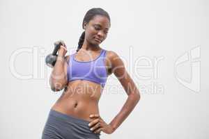 Fit woman lifting up kettlebell