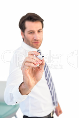 Focused businessman writing with marker