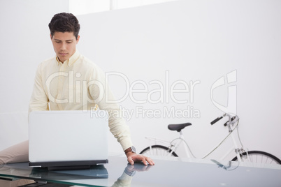 Thoughtful causal businessman using laptop