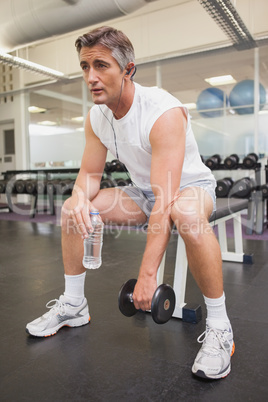 Fit man taking a break in the weights room