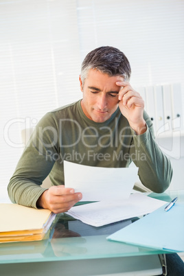 Smiling man with grey hair reading paper