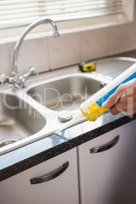 Plumber putting filling in between tiles