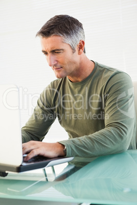 Concentrated casual man using laptop