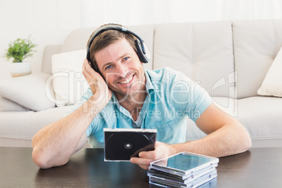 Smiling man listening to cds