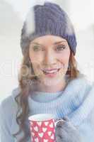 Pretty redhead in warm clothing holding mug