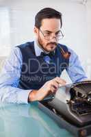 Businessman with pipe in his mouth working on typewriter
