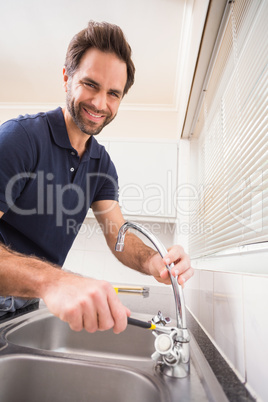 Plumber fixing the sink with wrench