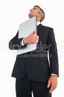 Businessman in suit holding his laptop proudly