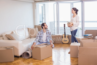 Cute couple unpacking cardboard boxes