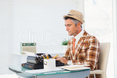 Retro man in straw hat typing on typewriter