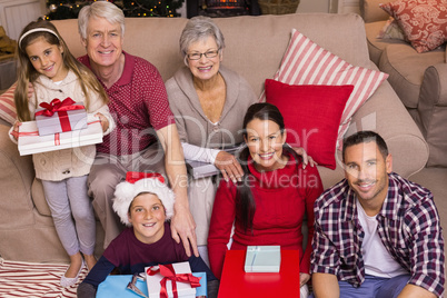 Happy family at christmas posing and holding gifts