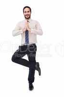 Smiling businessman standing in tree pose