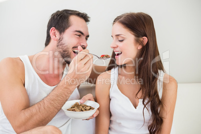 Young couple having breakfast in bed