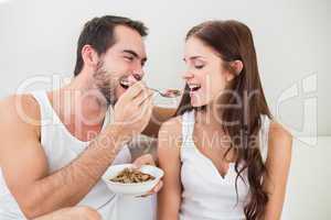 Young couple having breakfast in bed