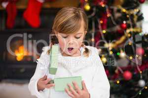 Shocked little girl opening a gift