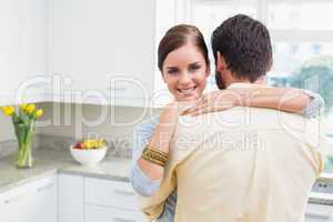 Young couple hugging with woman smiling at camera