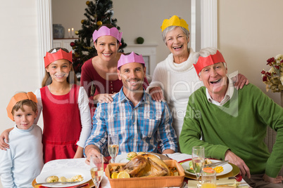 Happy extended family in party hat at dinner table