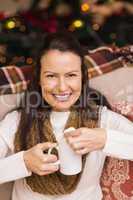 Happy brunette holding mug with marshmallow