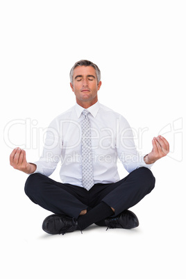 Zen businessman meditating in lotus pose