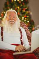 Happy santa claus typing on laptop