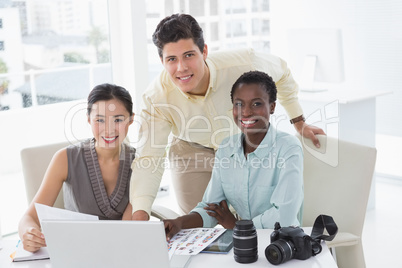 Casual business team looking at laptop together