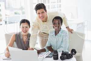 Casual business team looking at laptop together