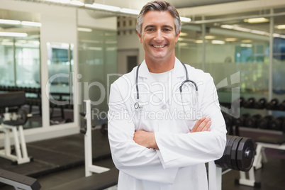 Confident doctor standing in weights room