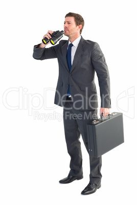 Businessman looking through binoculars